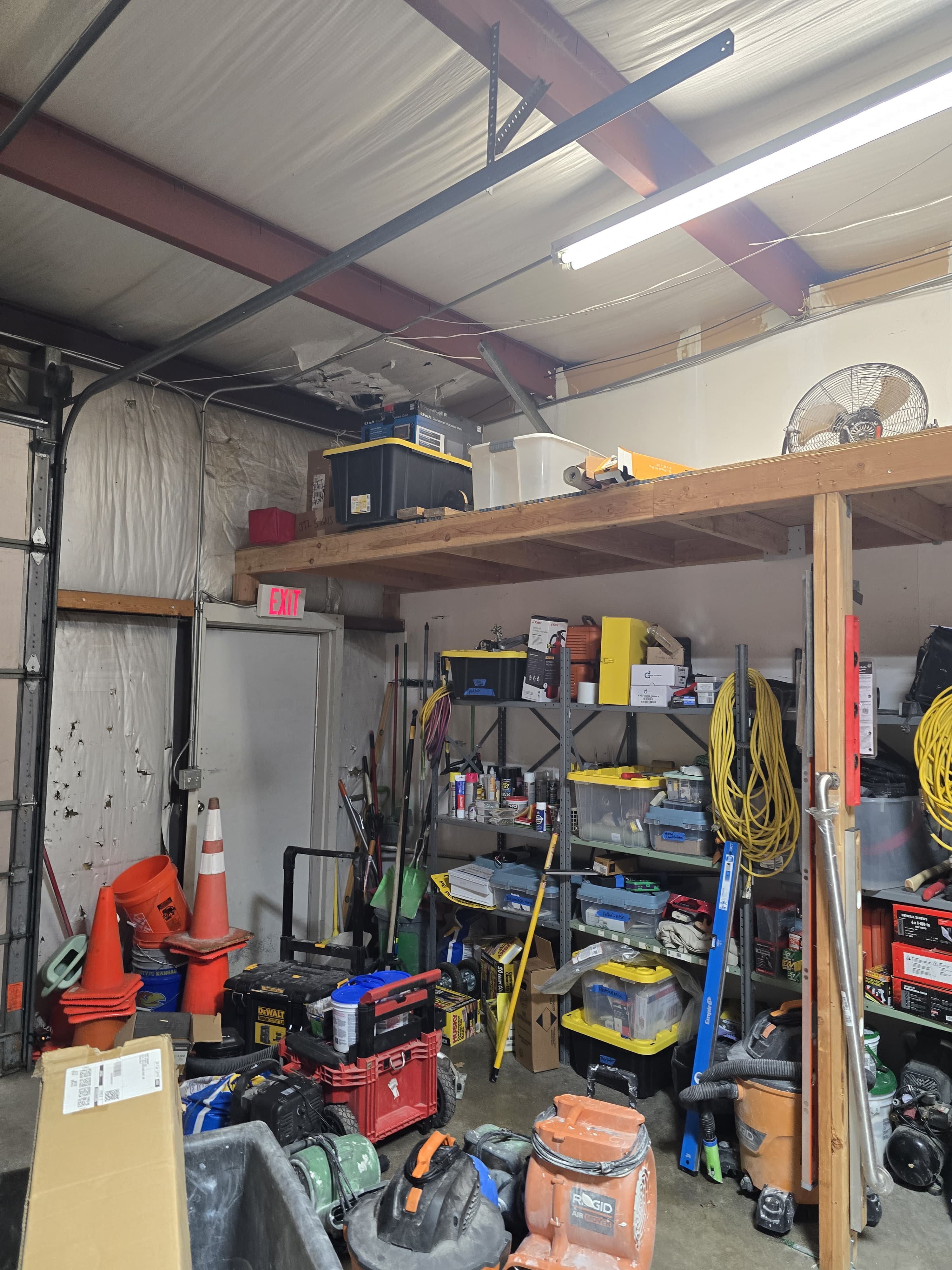 A workshop packed to the rafters: tools, totes, cones and a mezzanine of gear