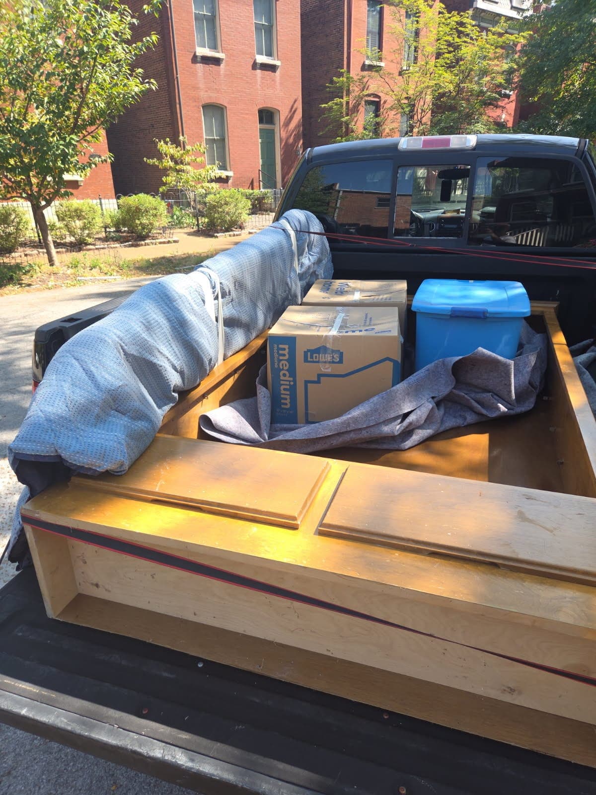 Furniture, Lowe’s boxes and a tote padded in the bed of a pickup