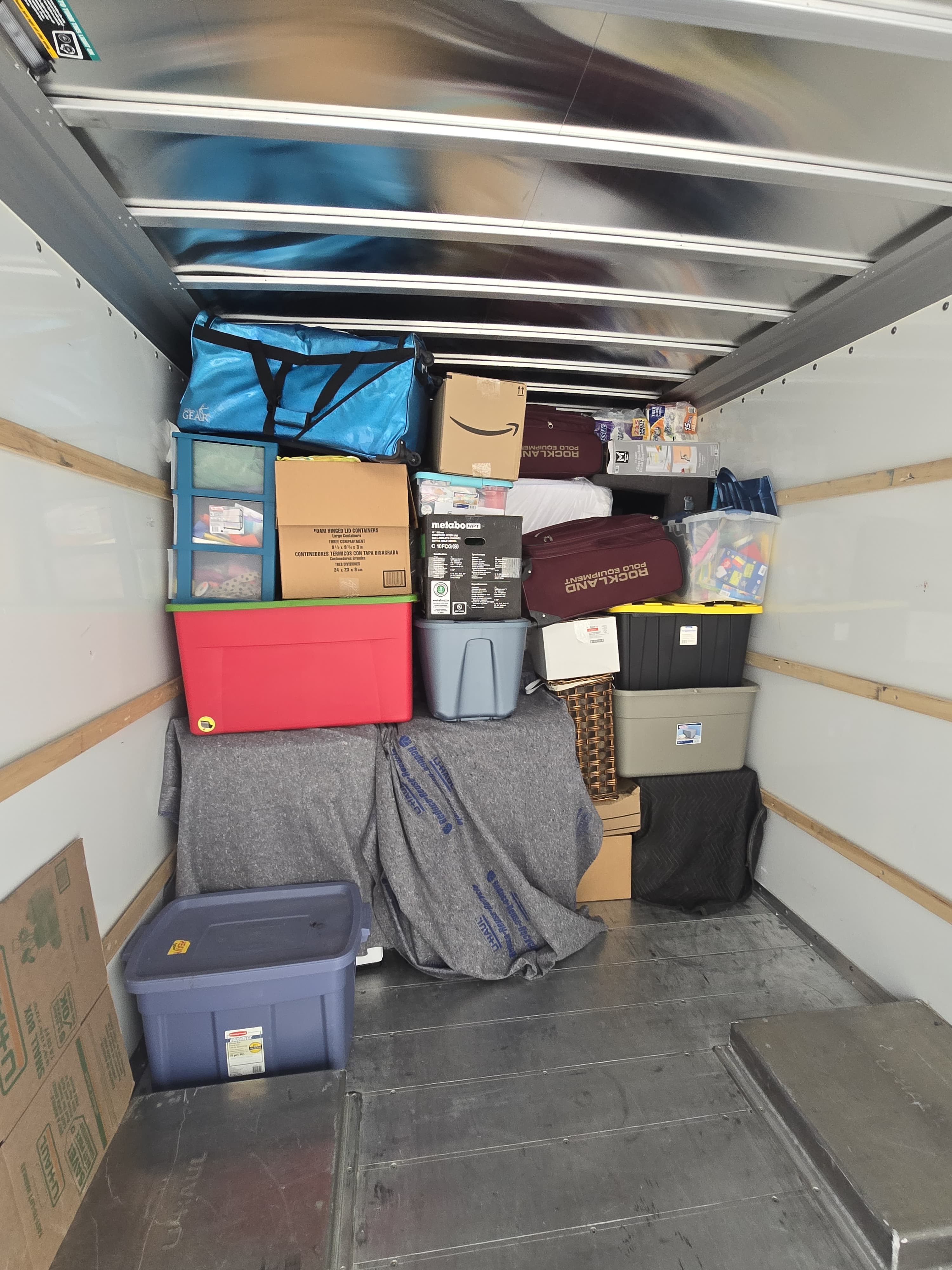 Boxes, totes and pad-wrapped furniture stacked inside a moving truck