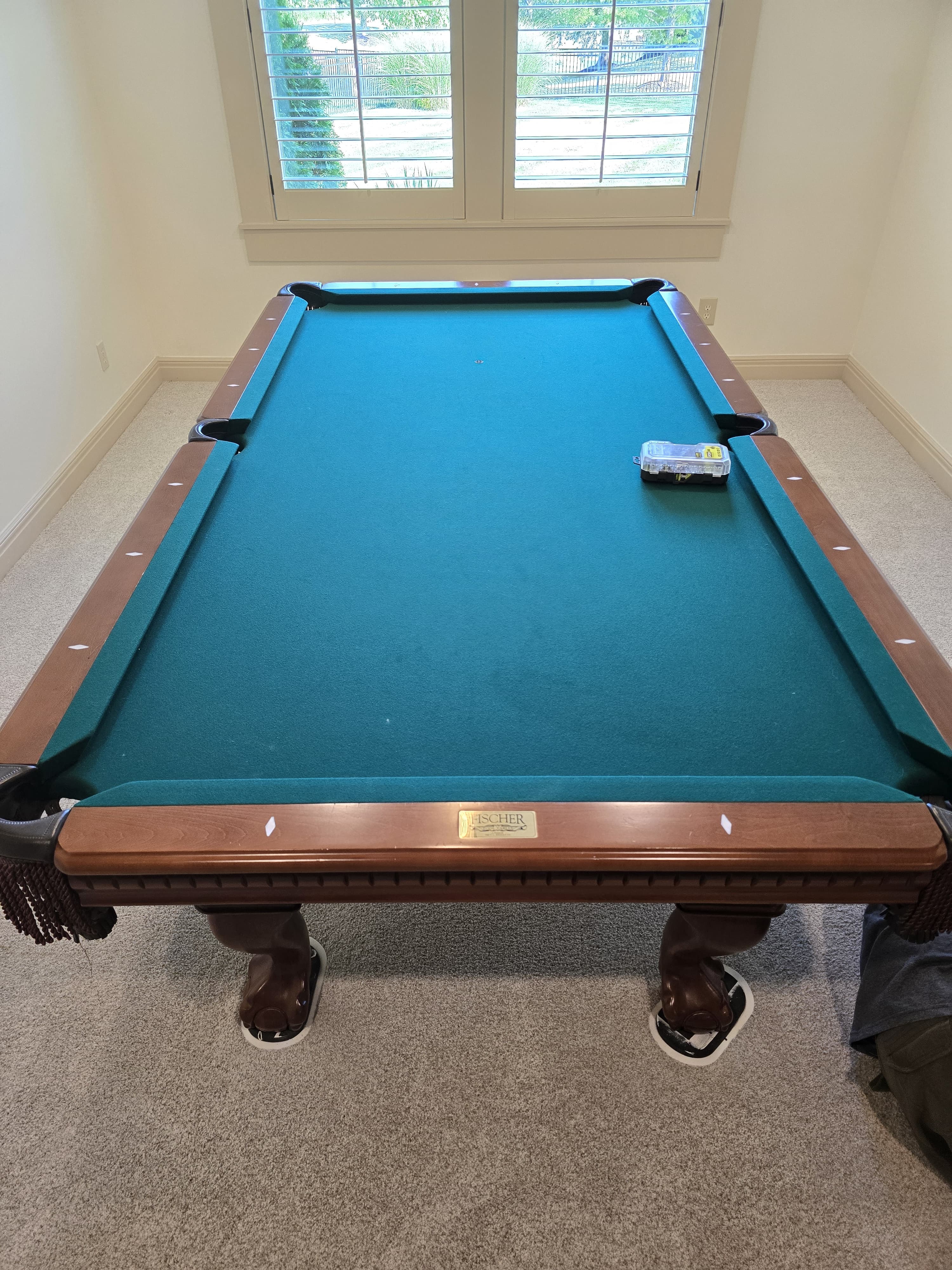 A Fischer pool table on furniture sliders, hardware box on the felt