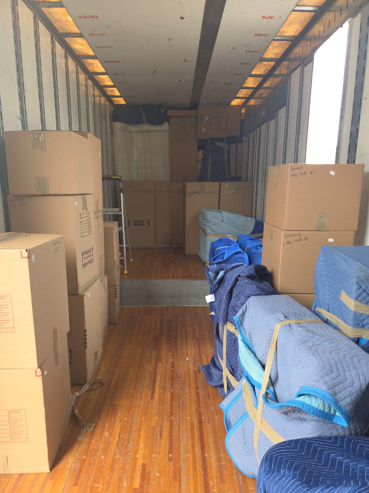 Dish-pack boxes, wardrobe cartons and pad-wrapped furniture loaded in a truck
