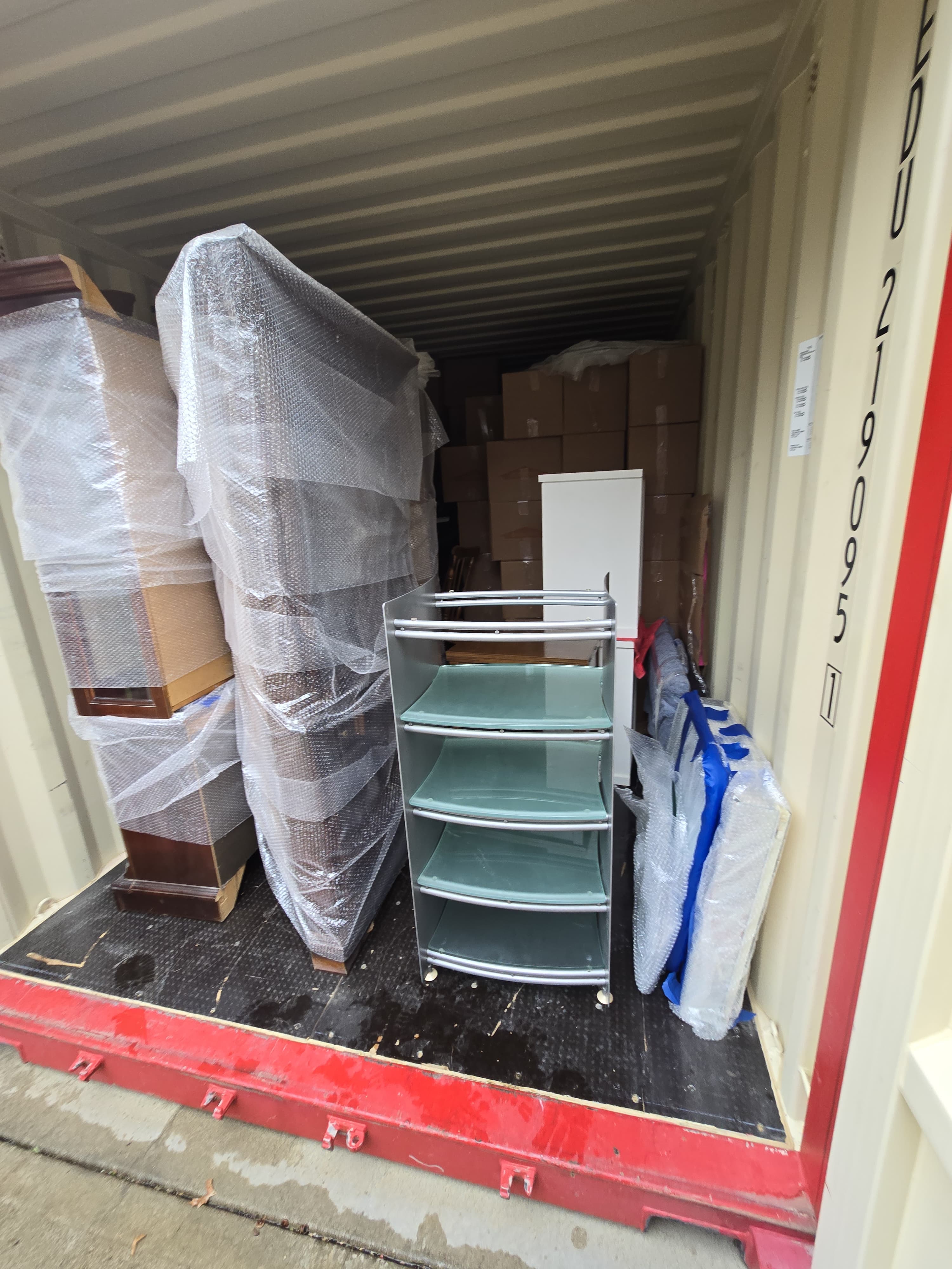 Tall cabinets and glass shelving wrapped and packed against a wall of boxes