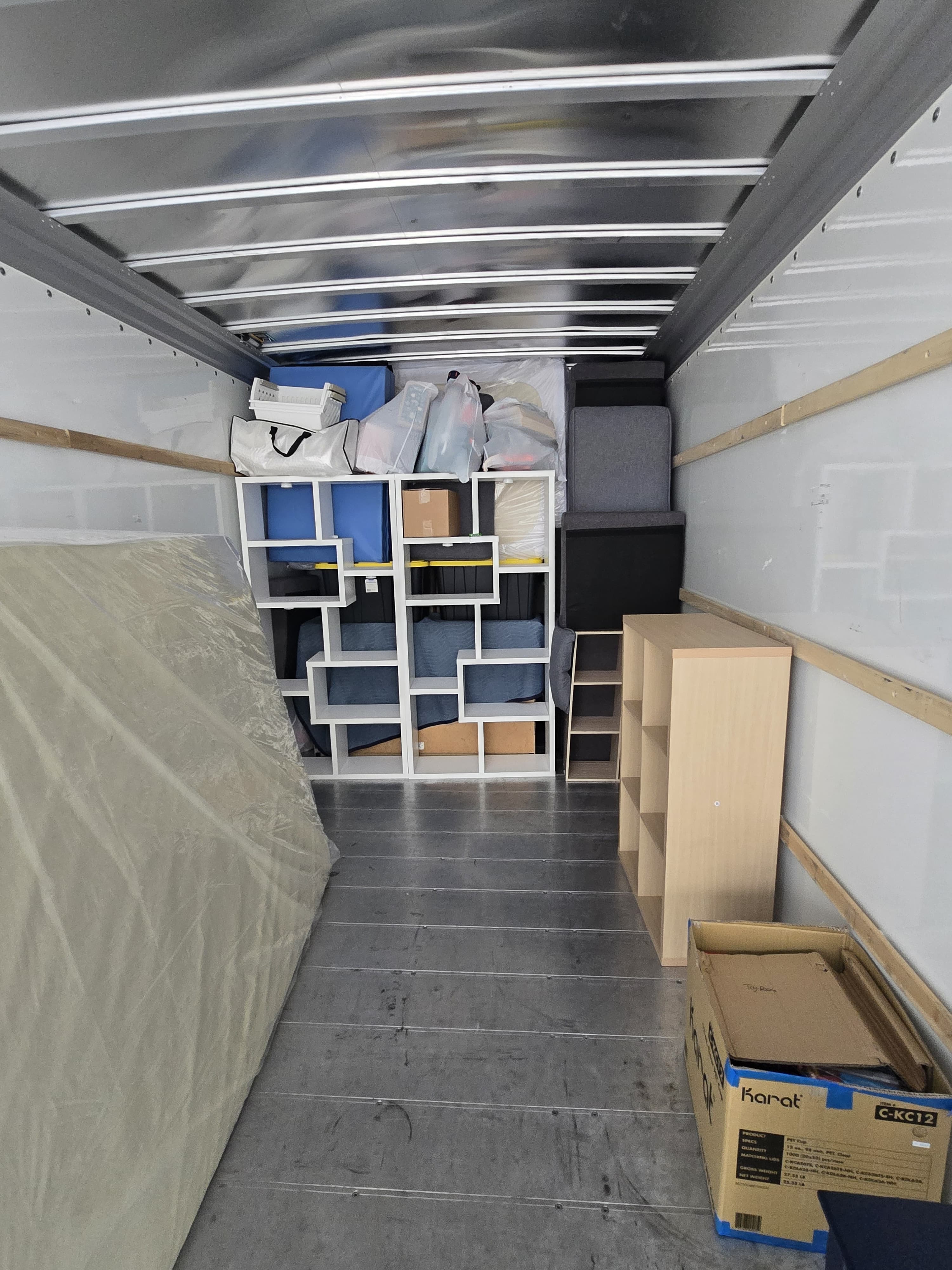 Cube shelves, a bookcase and a Karat box loaded in a moving truck
